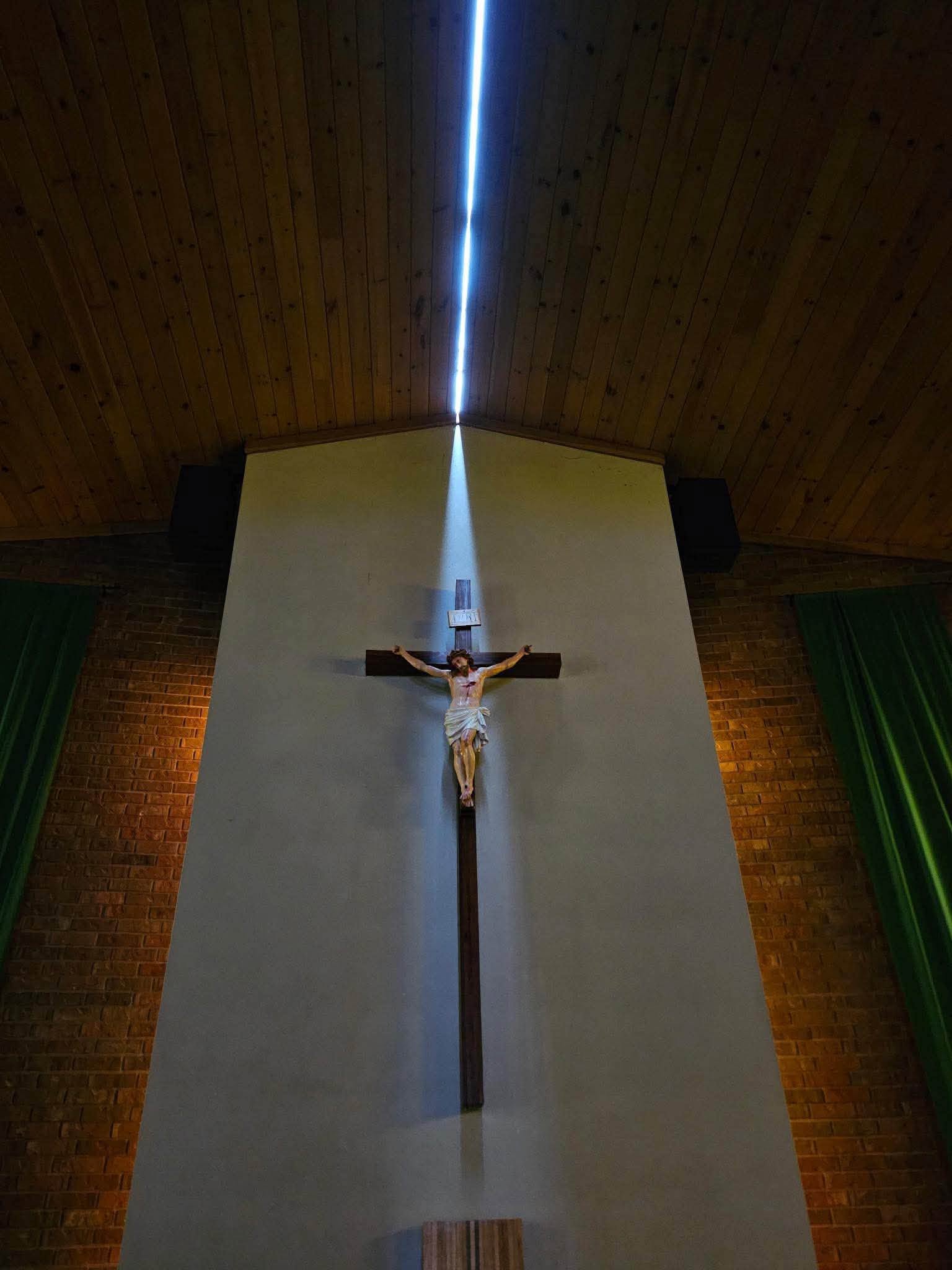 A beam of sunlight descending through the damaged roof toward the crucifix inside St. Mary's Church