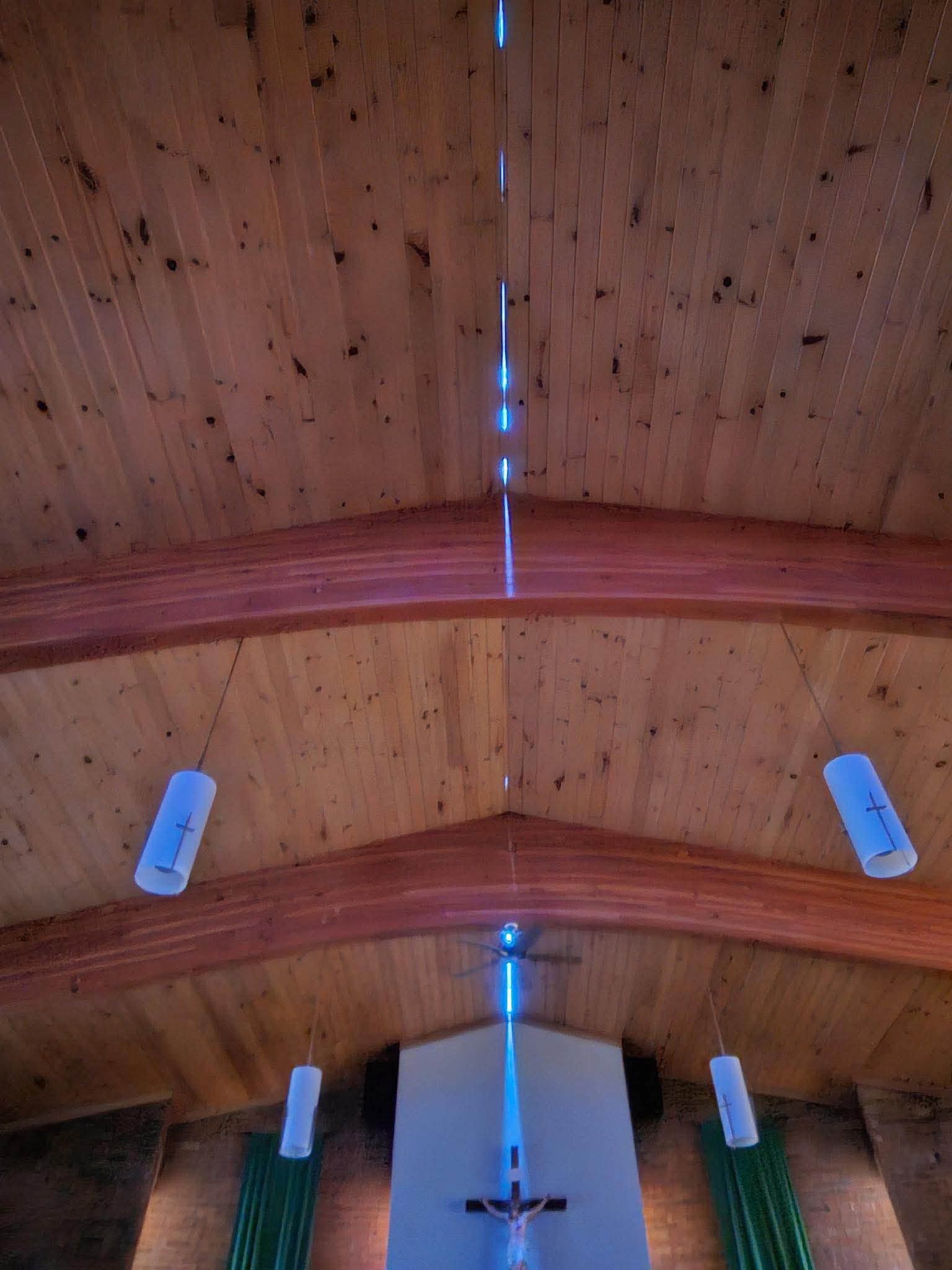A wider view inside St. Mary's Church showing sunlight entering through openings in the storm-damaged roof